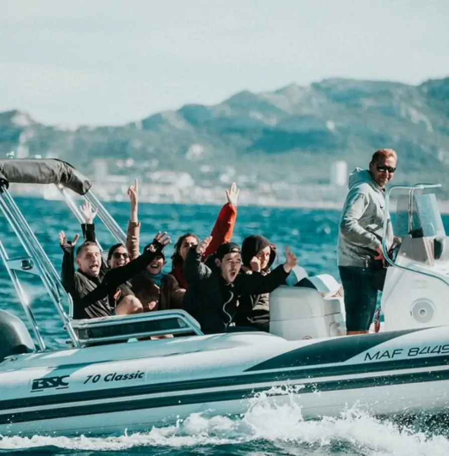 groupe de personnes s'amusant sur un bateau pneumatique en mer avec vue sur les montagnes