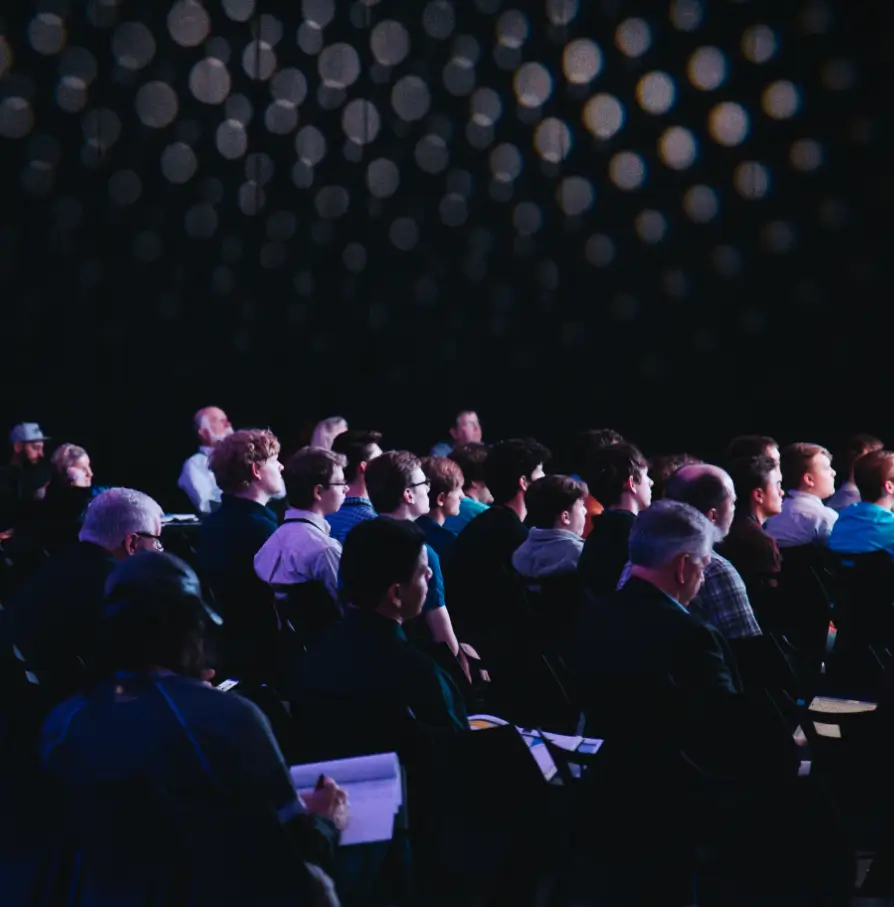 audience attentif lors d'une conférence avec éclairage tamisé
