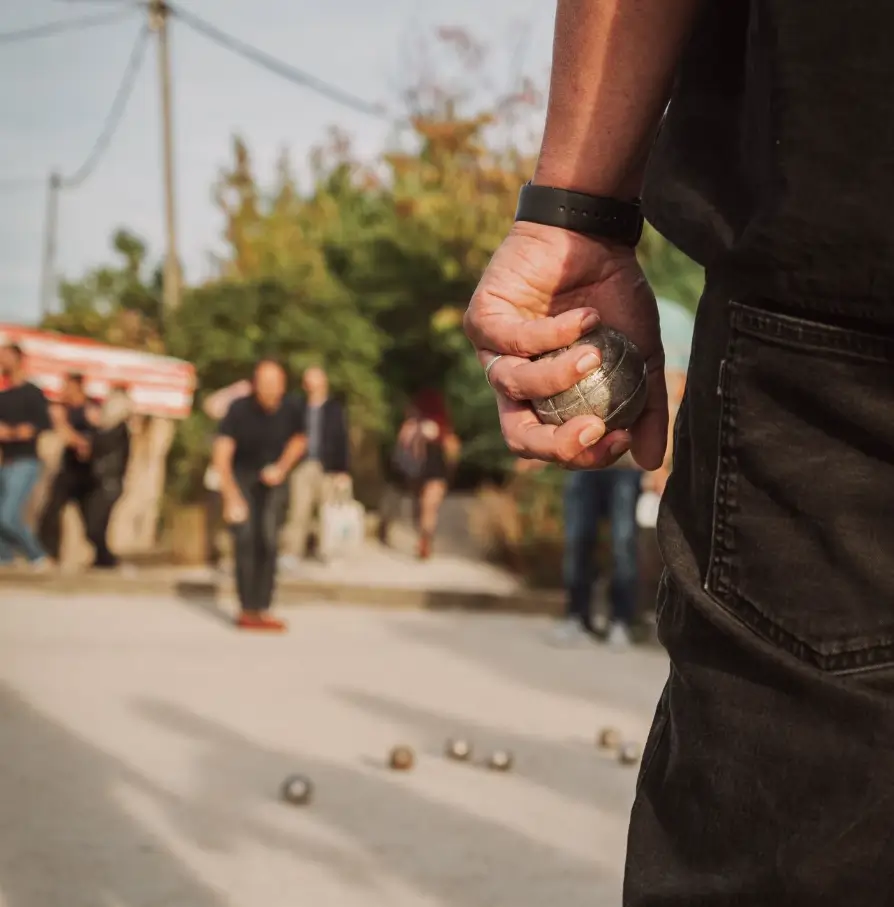 jeu de pétanque en plein air, joueur tenant une boule, compétition amicale